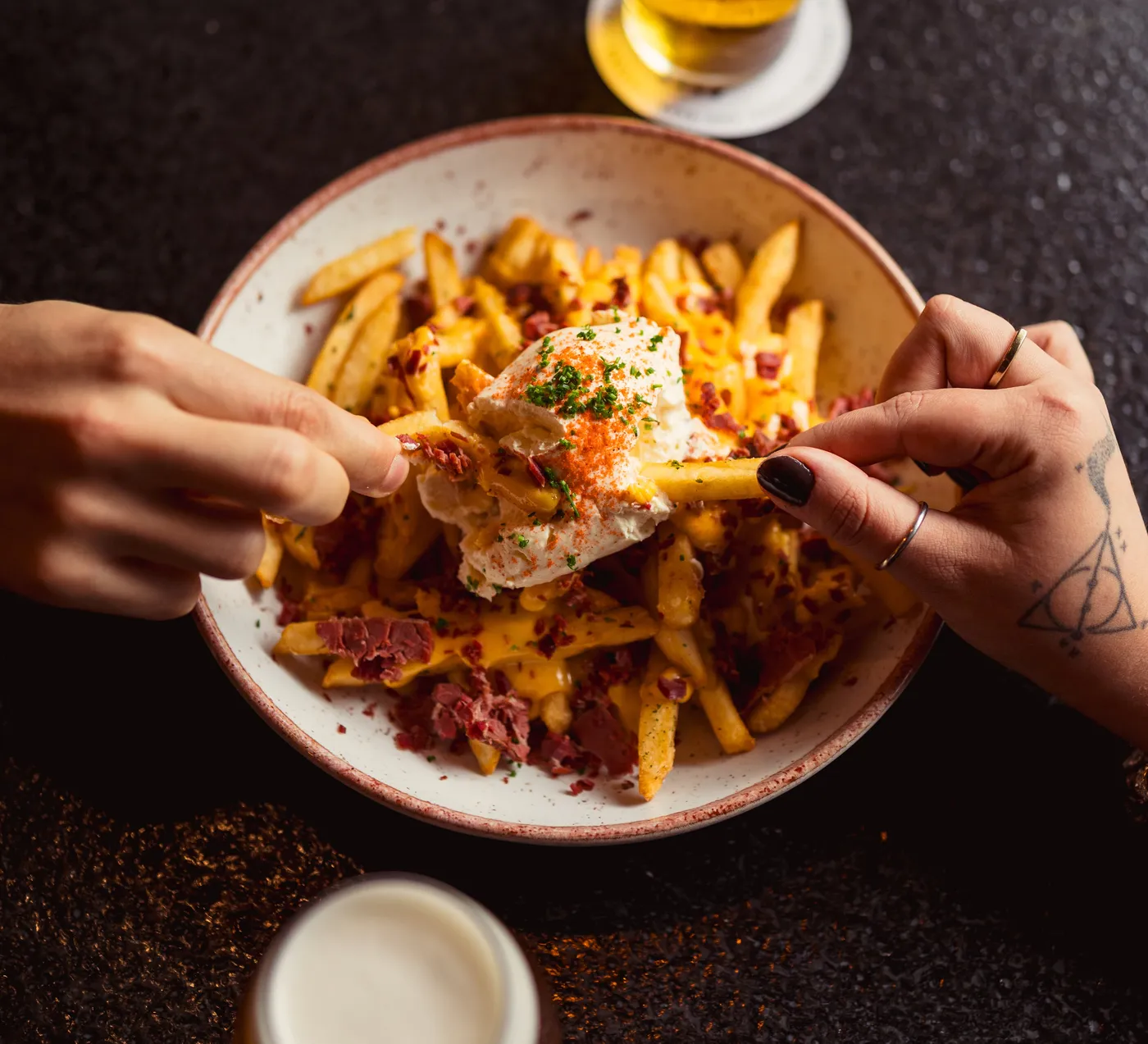 Fritas com ovo e dois copos de cerveja vistos de cima