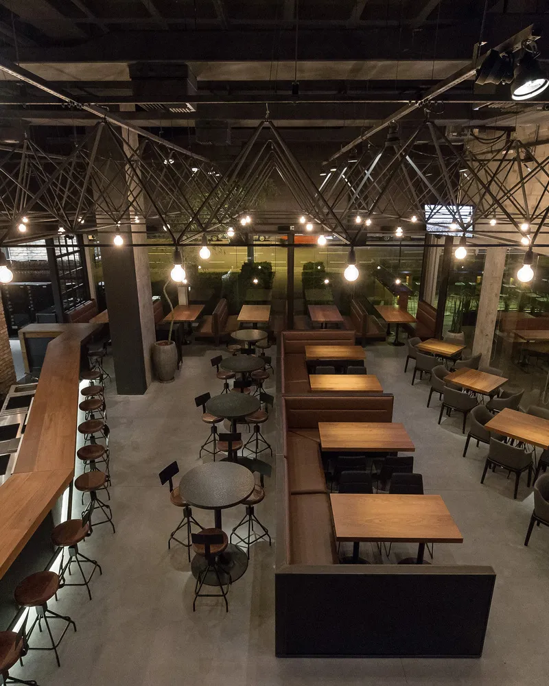 Salão do Roister 24 à noite, com as luzes penduradas sobre as mesas